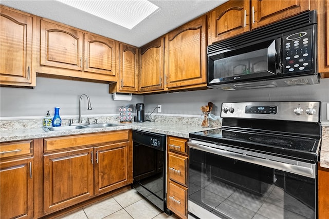 427 Harper Ave Unit 16, Auburn, AL 36830 - kitchen featuring black appliances, brown cabinetry, light tile patterned floors, and a textured ceiling