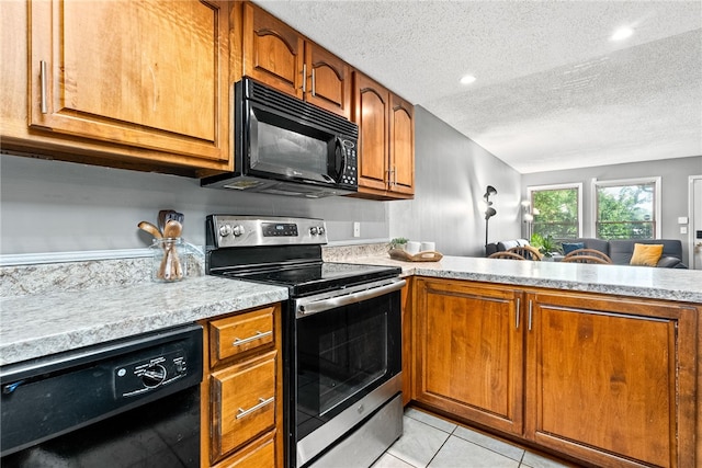 427 Harper Ave Unit 16, Auburn, AL 36830 - kitchen featuring black appliances, light countertops, brown cabinets, a textured ceiling, and light tile patterned flooring