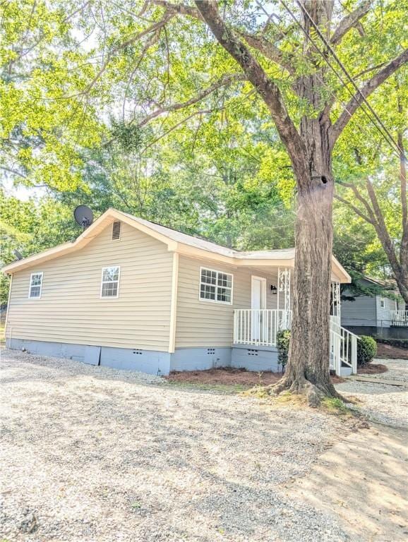 view of front facade with covered porch and crawl space