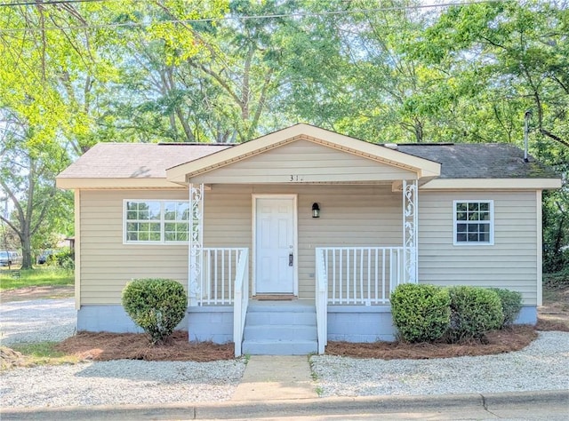 bungalow-style home featuring covered porch and a shingled roof