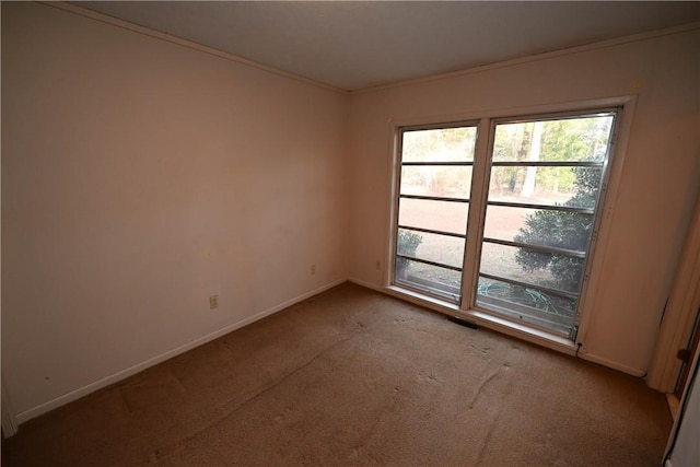 empty room with ornamental molding and light carpet