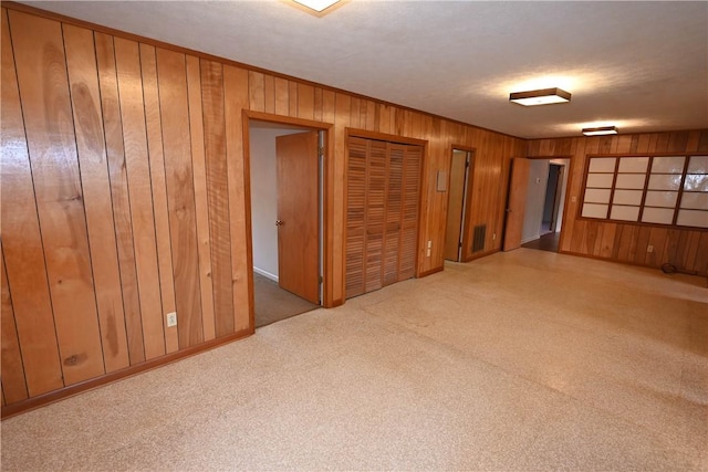 carpeted empty room with wooden walls