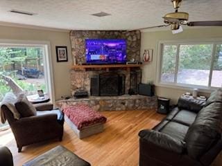720 Hollon Ave, Auburn, AL 36830 - living room with wood finished floors, a fireplace, plenty of natural light, a ceiling fan, and crown molding