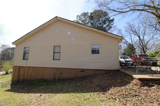 view of side of property featuring a patio area and crawl space