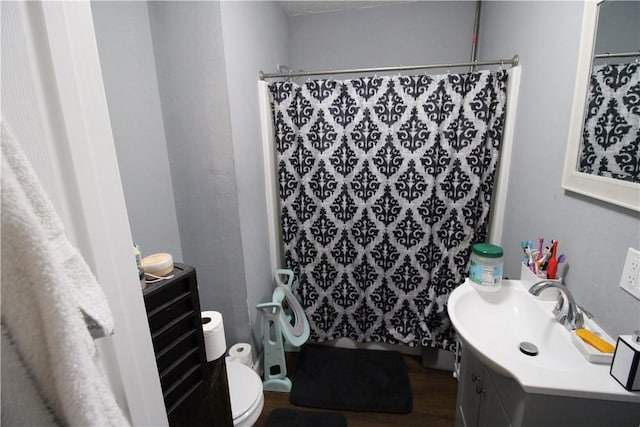 full bath featuring a shower with shower curtain, toilet, wood finished floors, and vanity