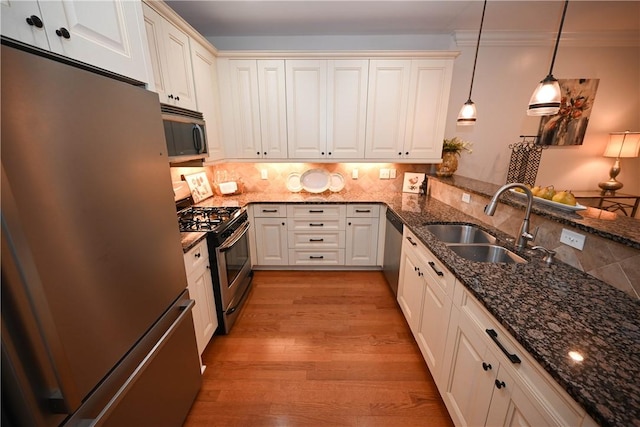 1758 Brookeview Ct, Auburn, AL 36830 - kitchen featuring appliances with stainless steel finishes, a sink, decorative light fixtures, light wood finished floors, and dark stone counters