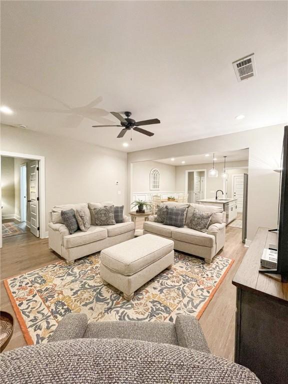 living room featuring ceiling fan and hardwood / wood-style flooring