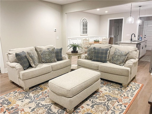 living room with sink and light wood-type flooring