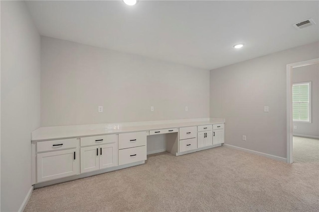 unfurnished office featuring light carpet and built in desk