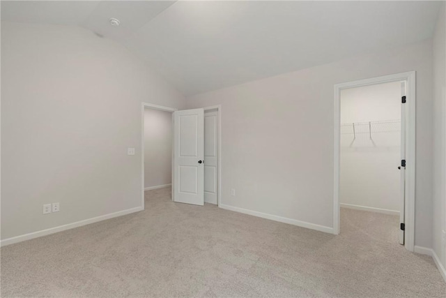 empty room with lofted ceiling and light colored carpet