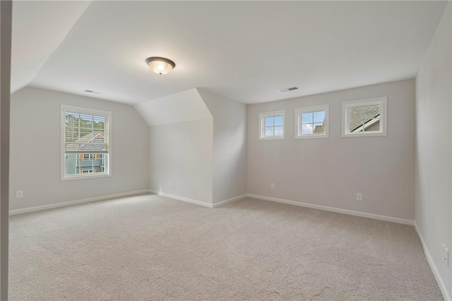 bonus room featuring lofted ceiling and light carpet