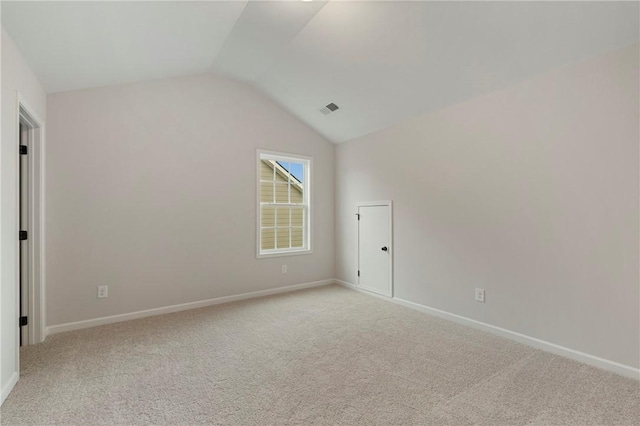 carpeted empty room featuring vaulted ceiling