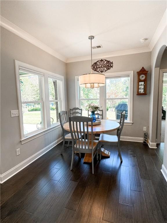 dining space featuring dark hardwood / wood-style floors and ornamental molding