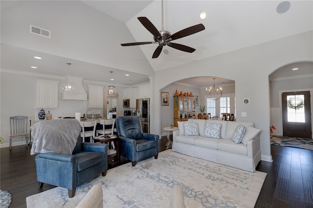 living room featuring plenty of natural light, dark wood-type flooring, and ceiling fan with notable chandelier