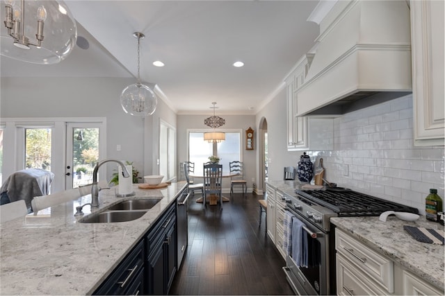 kitchen with appliances with stainless steel finishes, custom exhaust hood, sink, pendant lighting, and white cabinets