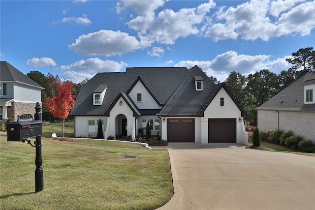 french country home featuring a front yard and a garage