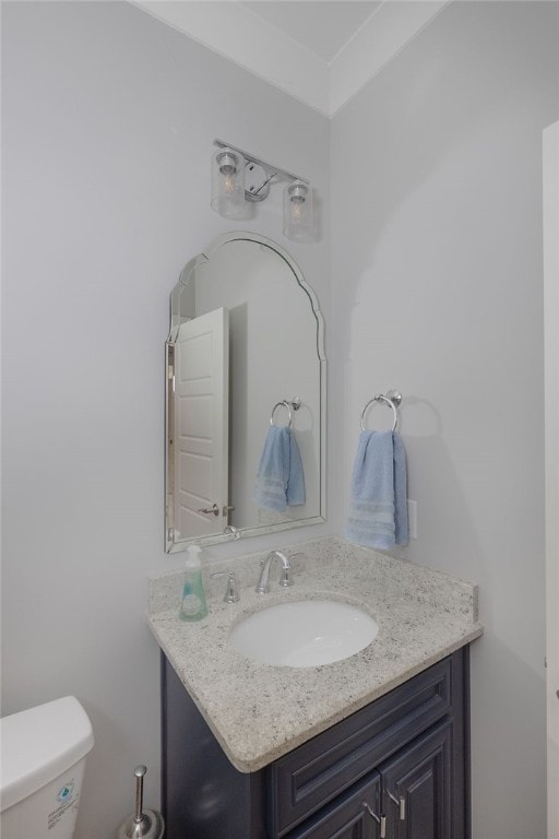 bathroom with vanity, toilet, and crown molding