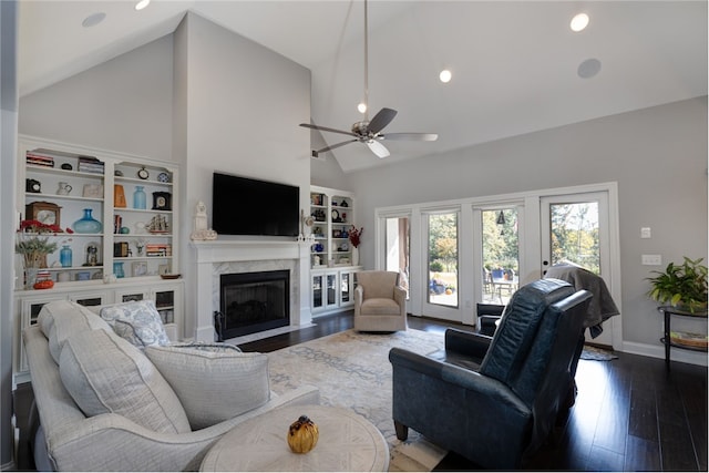 living room with ceiling fan, a high end fireplace, wood-type flooring, and high vaulted ceiling