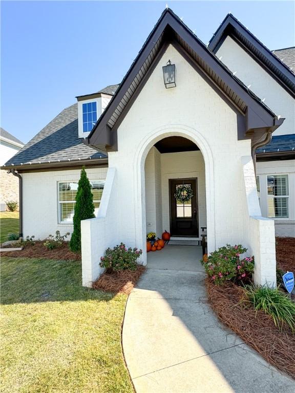 property entrance with a lawn