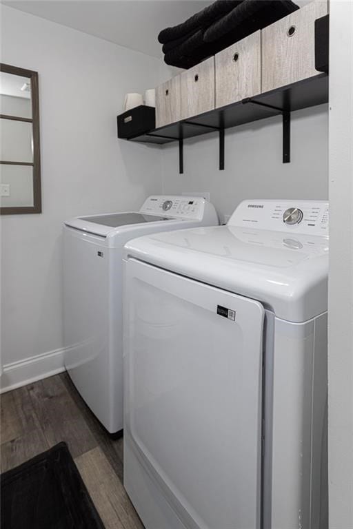 washroom with washing machine and dryer and dark wood-type flooring