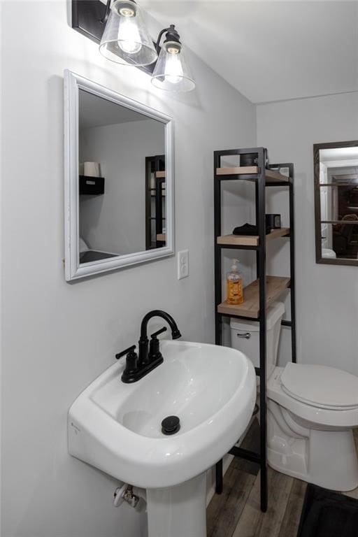 bathroom with sink, toilet, and wood-type flooring