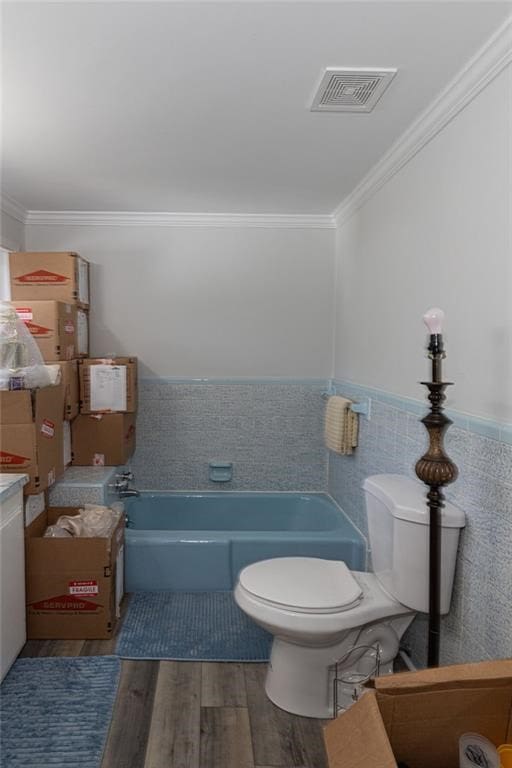 bathroom with toilet, hardwood / wood-style flooring, a washtub, and crown molding