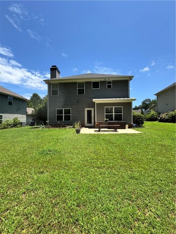 1521 Reynolds Dr, Auburn, AL 36830 - rear view of property with a chimney, a patio, and a lawn