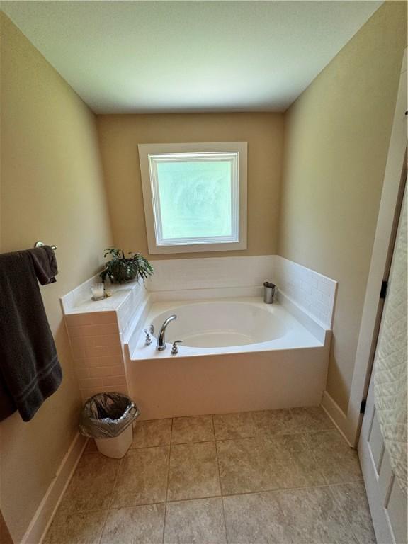 1521 Reynolds Dr, Auburn, AL 36830 - bathroom with a garden tub and tile patterned floors