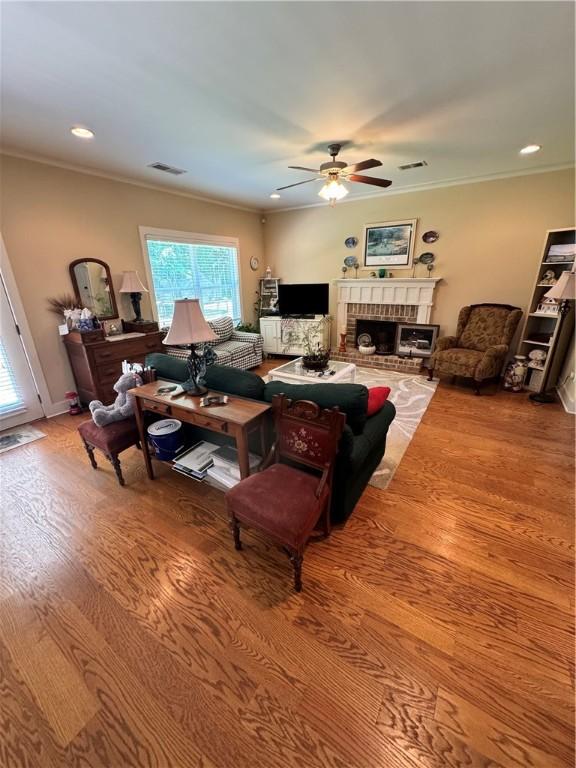 1521 Reynolds Dr, Auburn, AL 36830 - living room with a ceiling fan, wood finished floors, ornamental molding, a brick fireplace, and recessed lighting