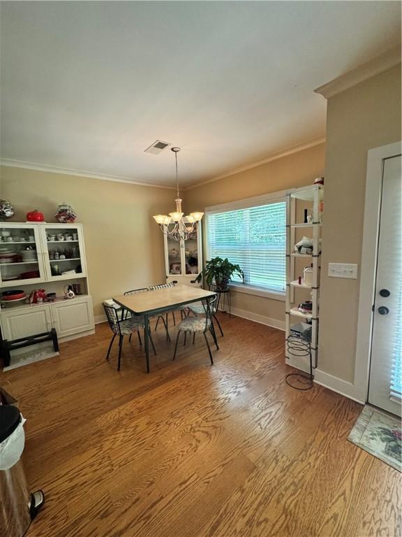 1521 Reynolds Dr, Auburn, AL 36830 - dining space with a chandelier, crown molding, and wood finished floors