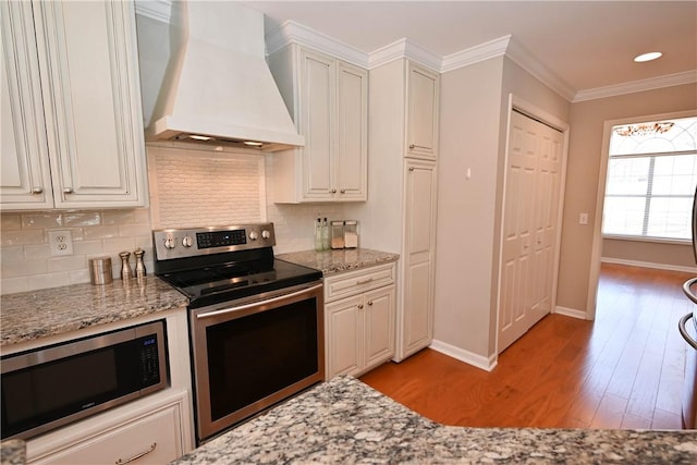 1798 Brookhaven Ct, Auburn, AL 36830 - kitchen featuring light wood-type flooring, appliances with stainless steel finishes, custom range hood, and backsplash