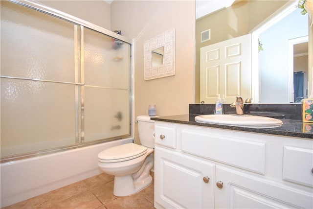 full bathroom featuring tile patterned floors, vanity, toilet, and shower / bath combination with glass door