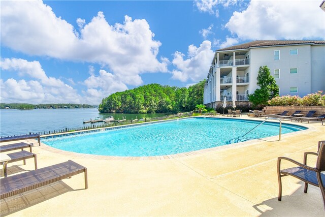 view of pool with a patio area and a water view