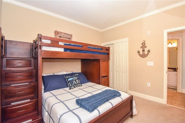 bedroom with connected bathroom, a closet, light colored carpet, and ornamental molding