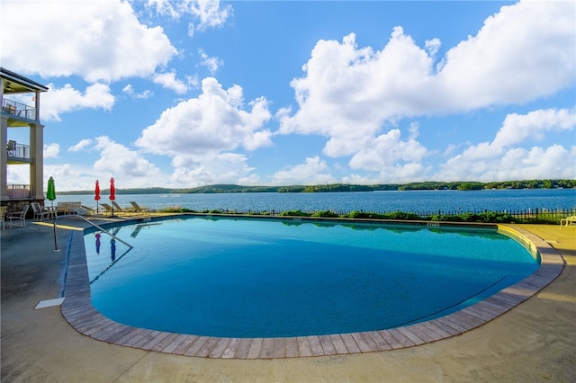 view of pool featuring a patio and a water view