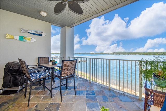 balcony with ceiling fan, a water view, and a beach view