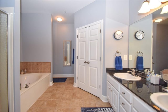 bathroom featuring tile patterned floors, a tub, and vanity