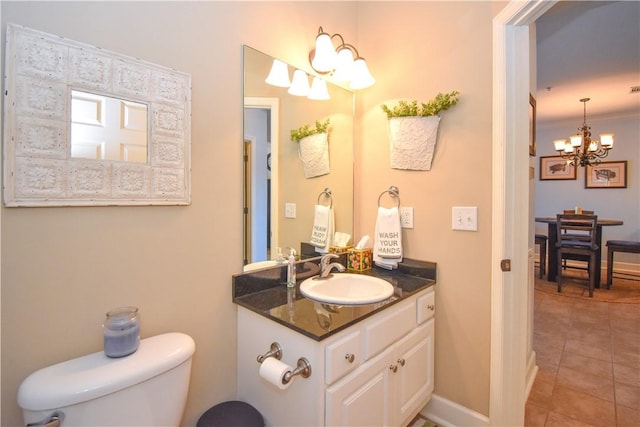 bathroom featuring tile patterned floors, vanity, toilet, and a chandelier