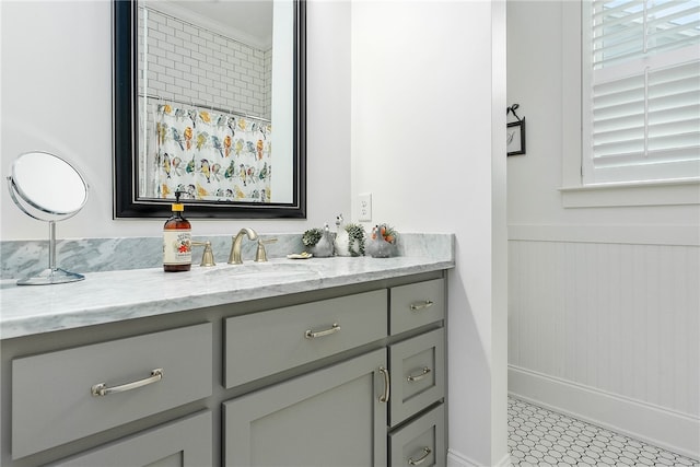 bathroom with a wainscoted wall and vanity