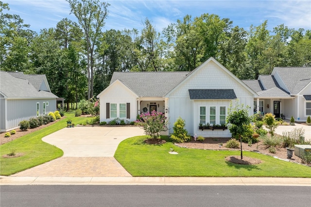 modern farmhouse style home with board and batten siding, concrete driveway, and a front lawn