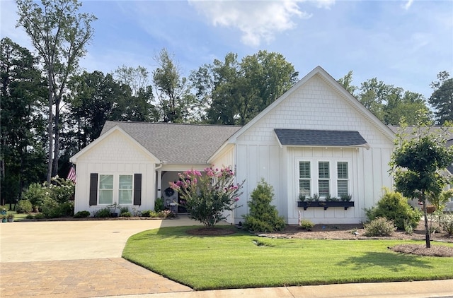 modern inspired farmhouse featuring a front lawn, board and batten siding, and driveway