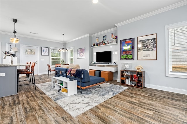 living room with crown molding, a notable chandelier, wood finished floors, and baseboards