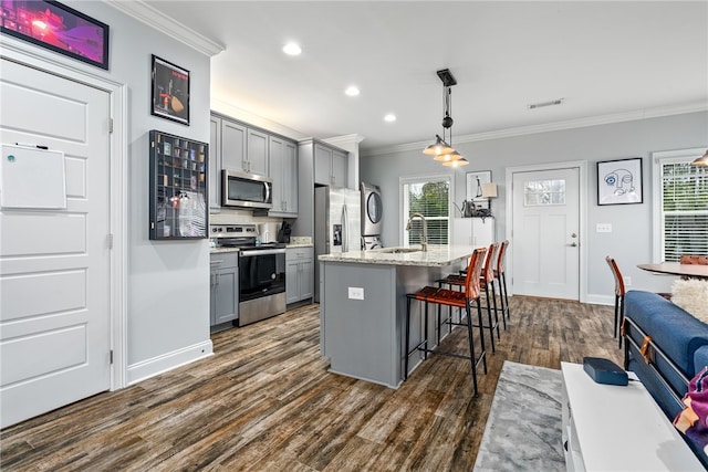 kitchen featuring visible vents, gray cabinets, appliances with stainless steel finishes, and ornamental molding