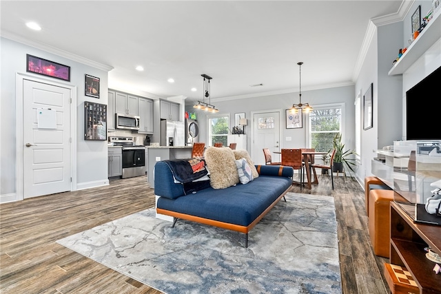 living area with crown molding, recessed lighting, wood finished floors, and baseboards