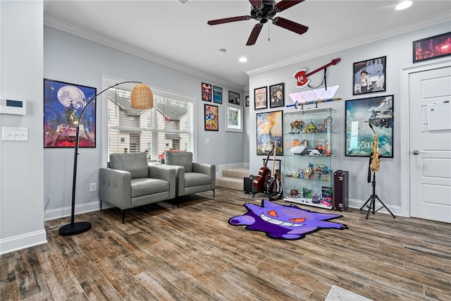 rec room with ceiling fan, wood finished floors, baseboards, and ornamental molding