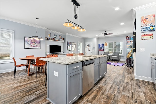 kitchen featuring gray cabinetry, a sink, stainless steel dishwasher, open floor plan, and crown molding