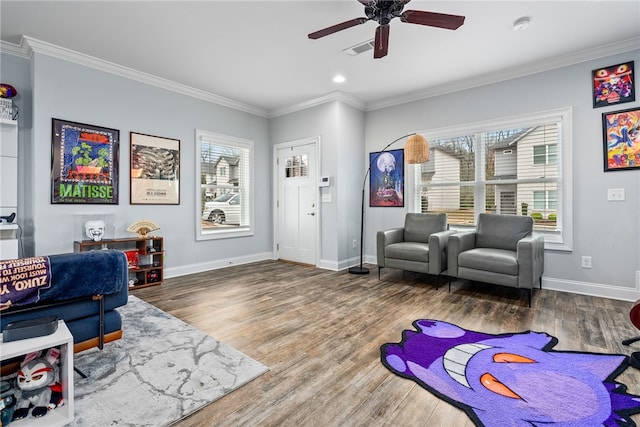 sitting room featuring visible vents, crown molding, baseboards, wood finished floors, and a ceiling fan