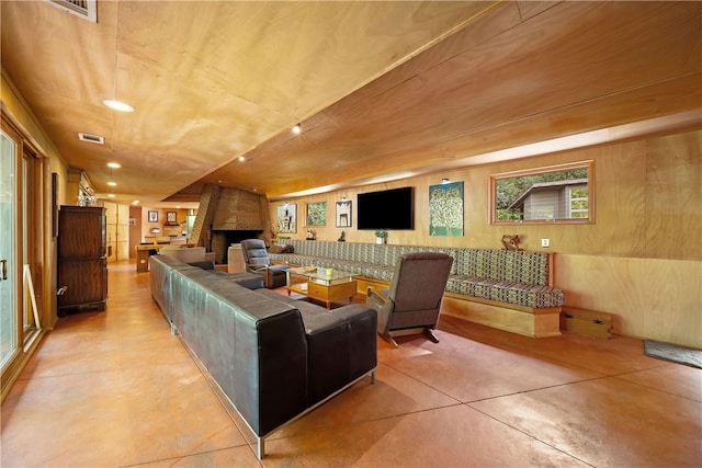 living room featuring visible vents, concrete flooring, a fireplace, and recessed lighting