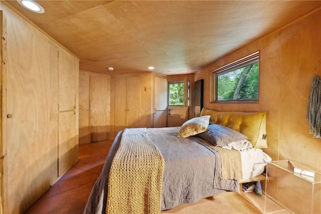 bedroom with recessed lighting, tile patterned flooring, and wood walls
