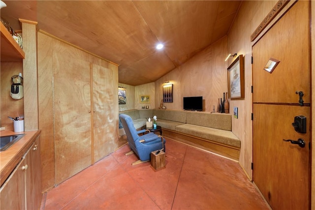 living area with concrete flooring, lofted ceiling, and wooden ceiling